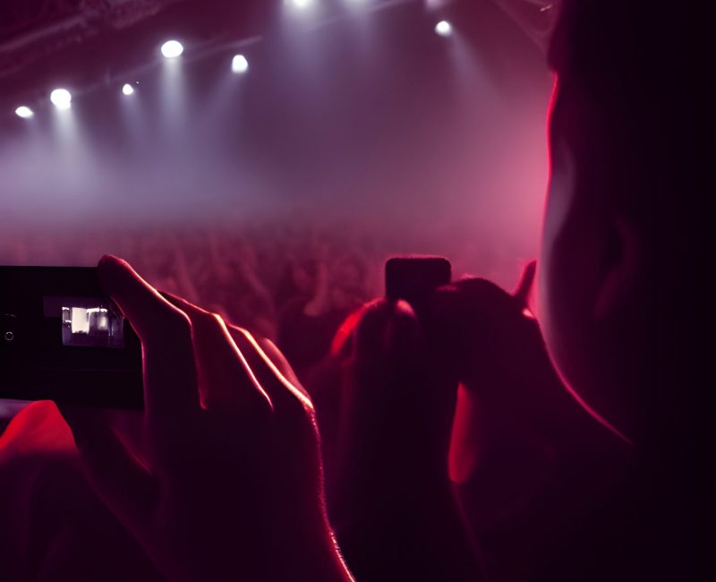 A boy uses his phone to record a video at a metal concert digital art, trending on artstation, hd